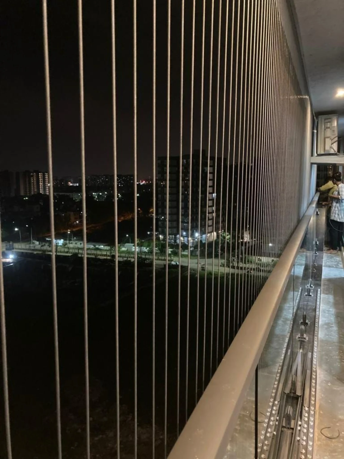 Invisible grill installation viewed from a high-rise corridor at night